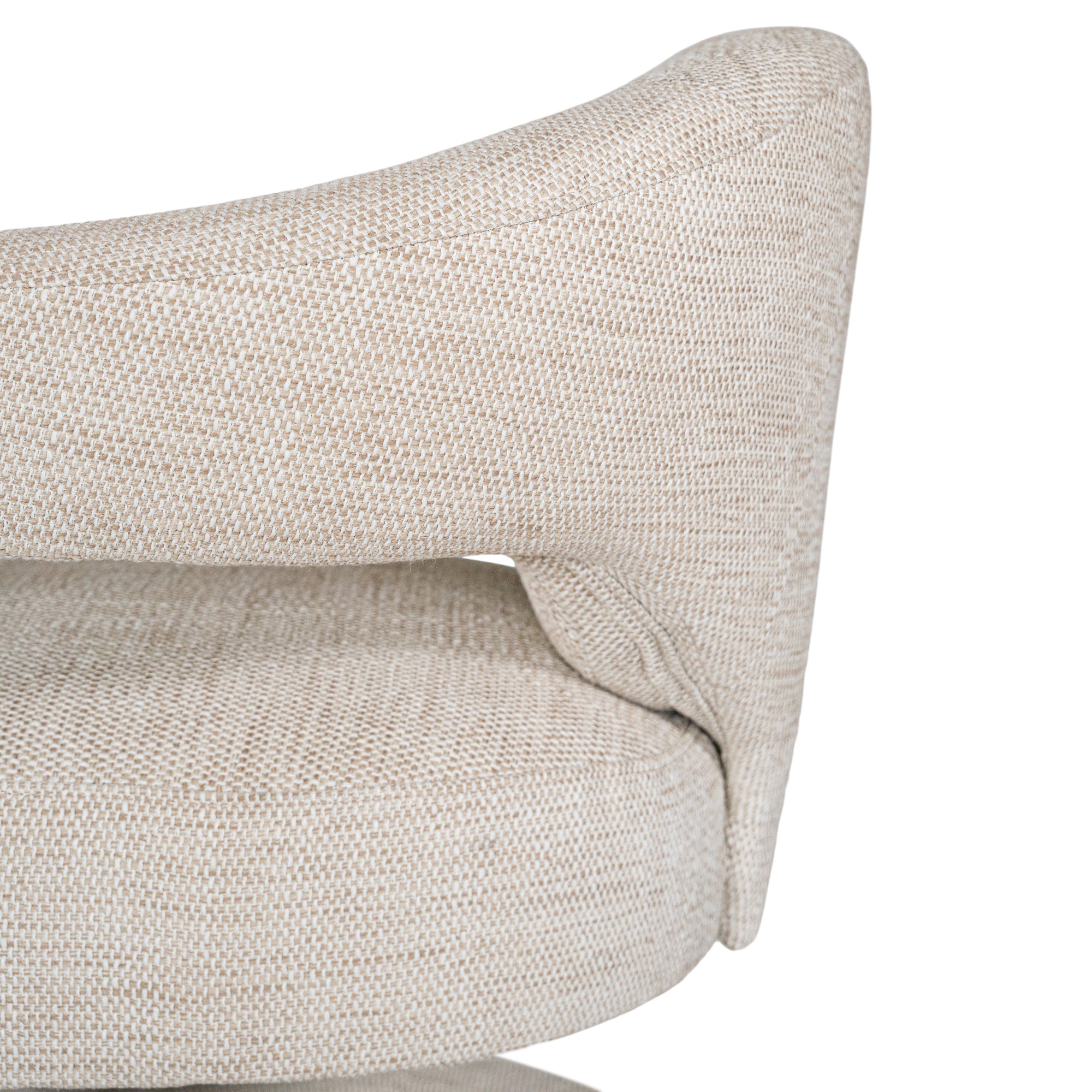 Contemporary upholstered armchair in a soft beige fabric, featuring a sculptural curved frame and plush seating for a modern, sophisticated look.