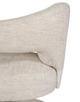 Contemporary upholstered armchair in a soft beige fabric, featuring a sculptural curved frame and plush seating for a modern, sophisticated look.