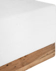 A contemporary white coffee table with a rustic wooden base, featuring a minimalist block design. This versatile piece blends modern aesthetics with organic textures, perfect for living spaces that embrace natural materials and clean lines