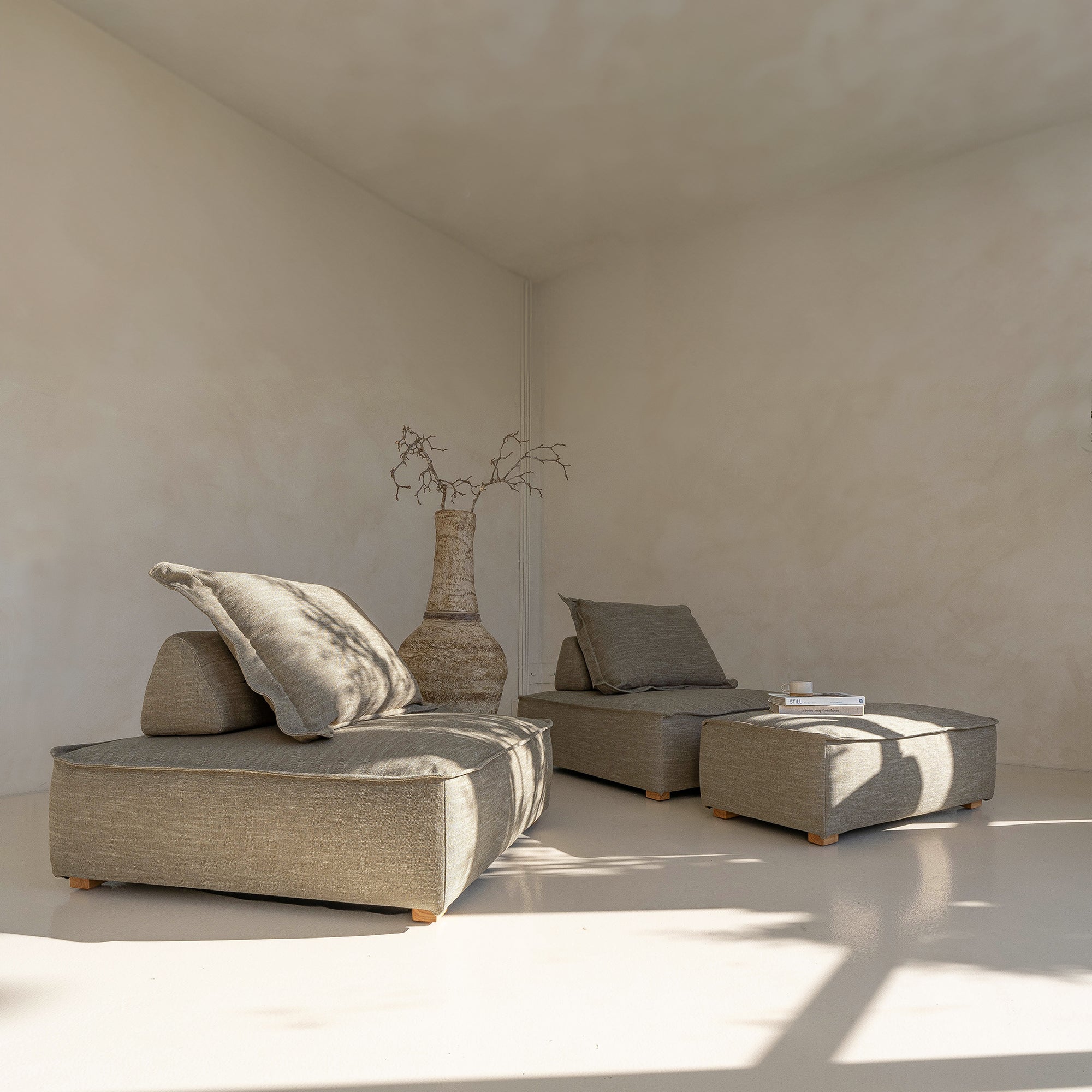A serene living space featuring a moss modular lounge set, designed for effortless comfort and modern relaxation. Styled with a textured vase and neutral décor, bathed in warm natural light