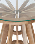 Nakuru side table in natural teak with round glass top and sculptural slat base isolated on a light background