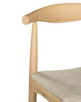Kulala Living natural wood dining chair featuring a sculpted backrest and a lightly upholstered seat in a neutral fabric. A blend of minimalist design and organic materials, perfect for modern dining spaces.