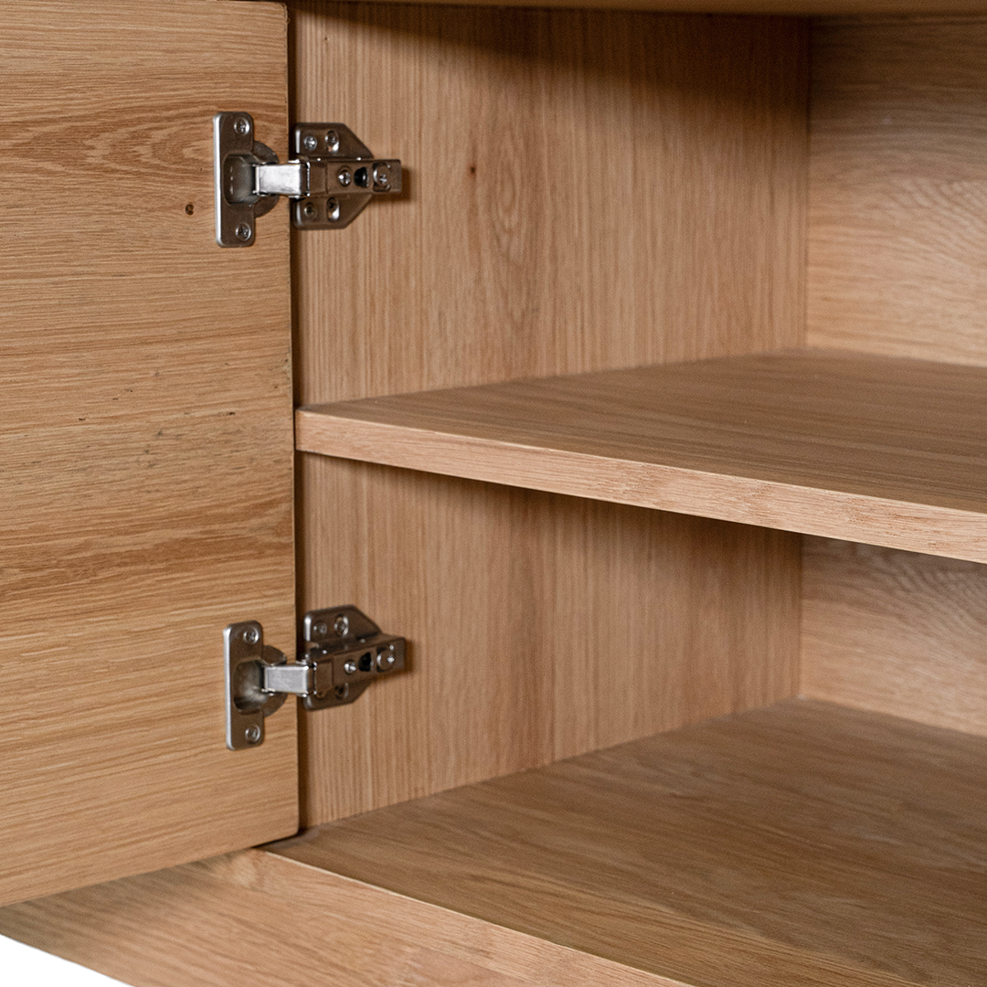 Natural oak TV unit featuring a sleek curved design with ample storage, including cabinets, a drawer, and an open shelf for media organisation