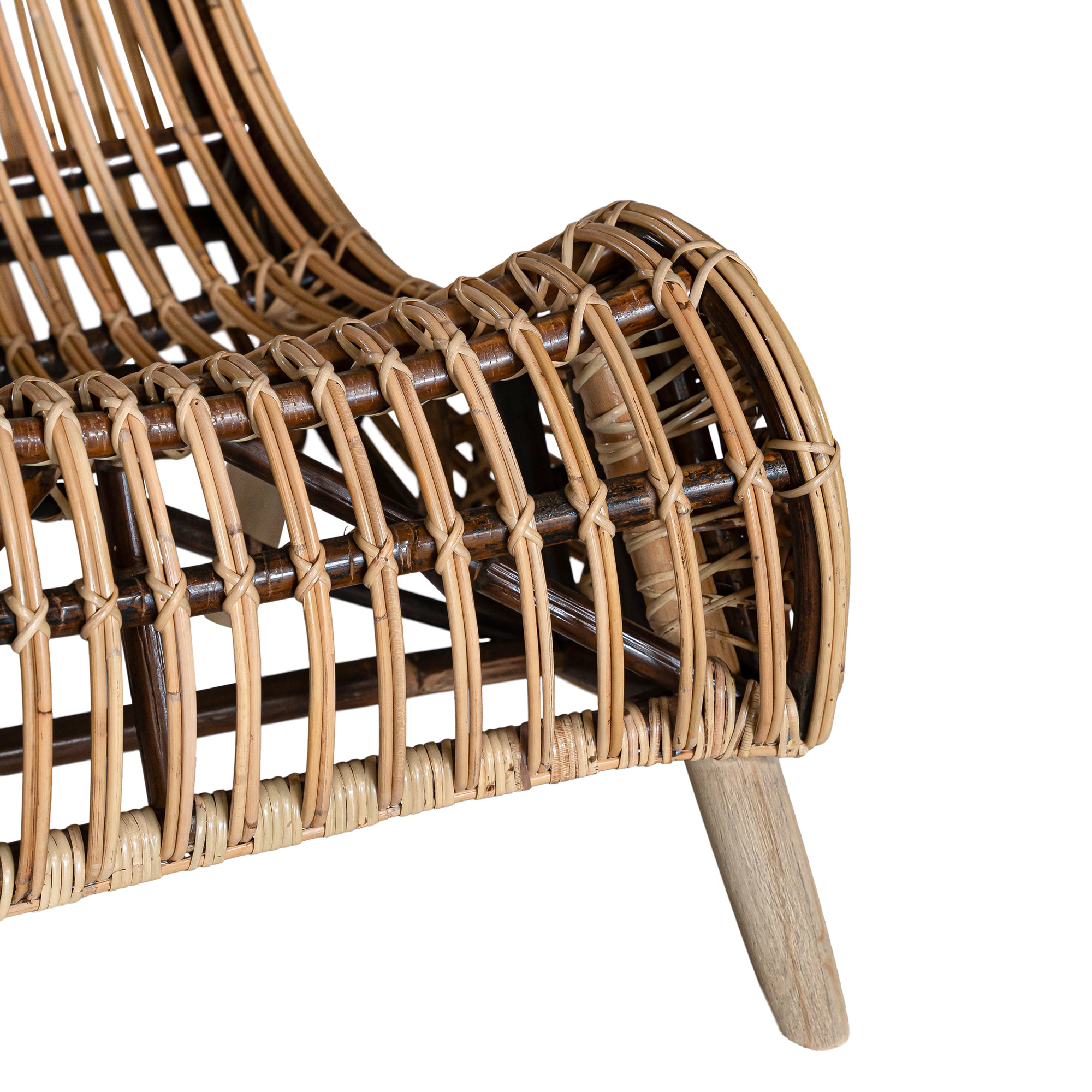 A sculptural natural rattan lounge chair with a curved, low-profile silhouette and sleek wooden legs. The woven design adds texture, while the deep seat and ergonomic shape offer comfort and relaxation.