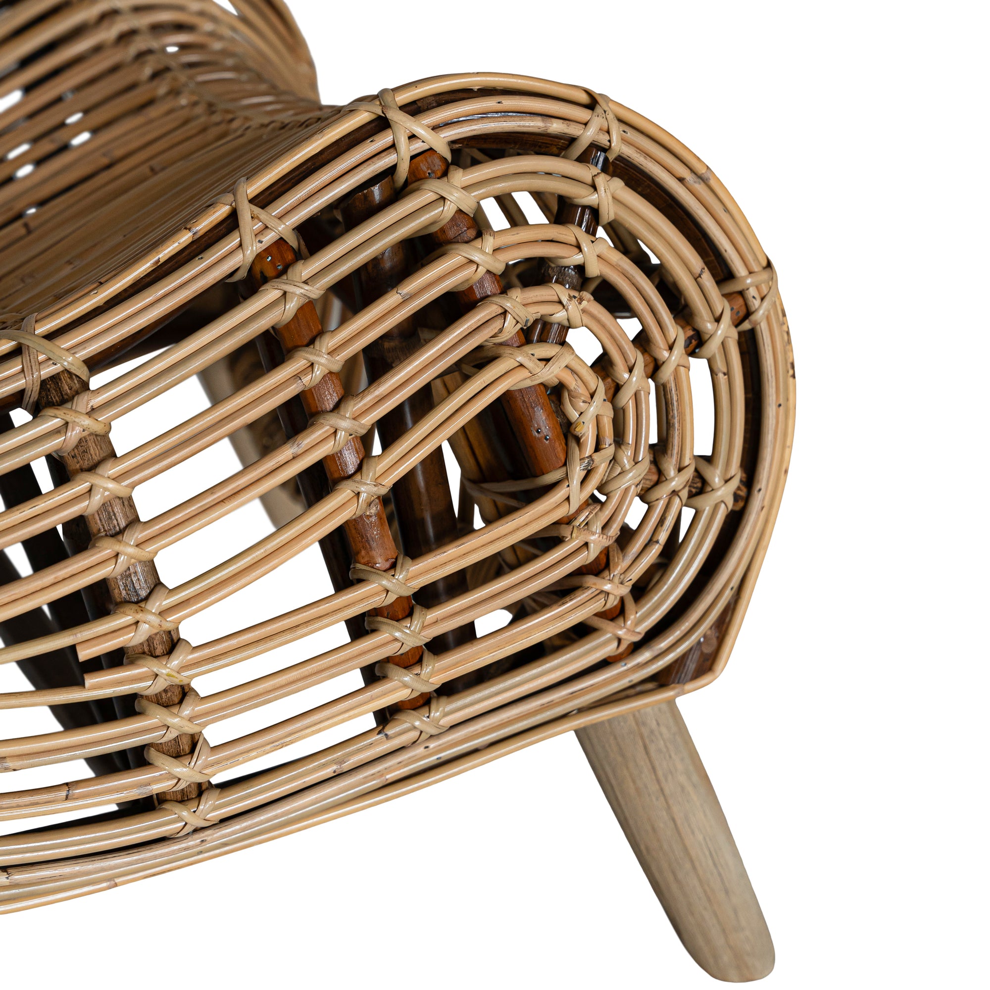 A sculptural natural rattan lounge chair with a curved, low-profile silhouette and sleek wooden legs. The woven design adds texture, while the deep seat and ergonomic shape offer comfort and relaxation