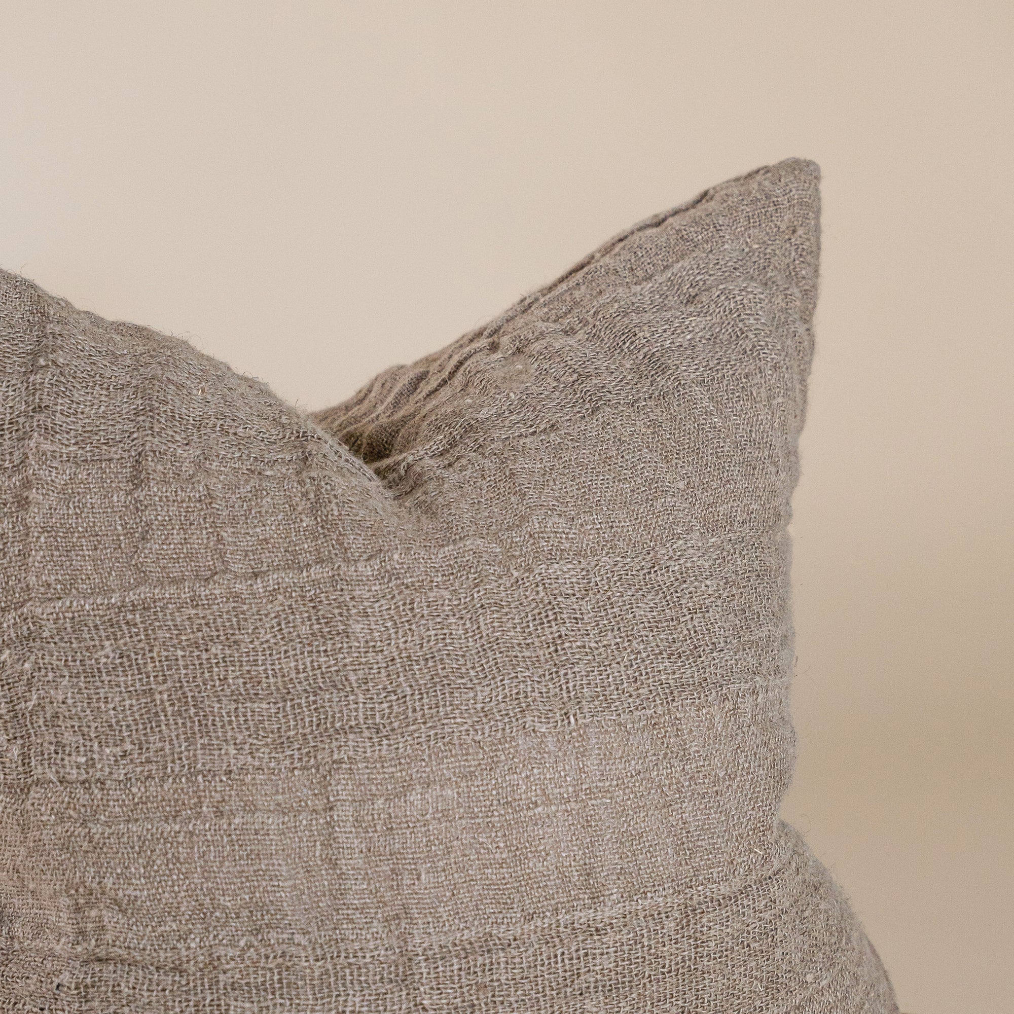 Natural linen cushion with a textured finish in a soft, neutral tone, perfect for adding warmth and comfort to any living space