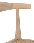Natural timber dining chair with woven cane seat and curved backrest, ideal for relaxed, coastal-inspired dining spaces