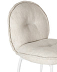 Contemporary natural upholstered dining chair with a plush, rounded backrest and cushioned seat, supported by sleek black metal legs for a sophisticated modern look