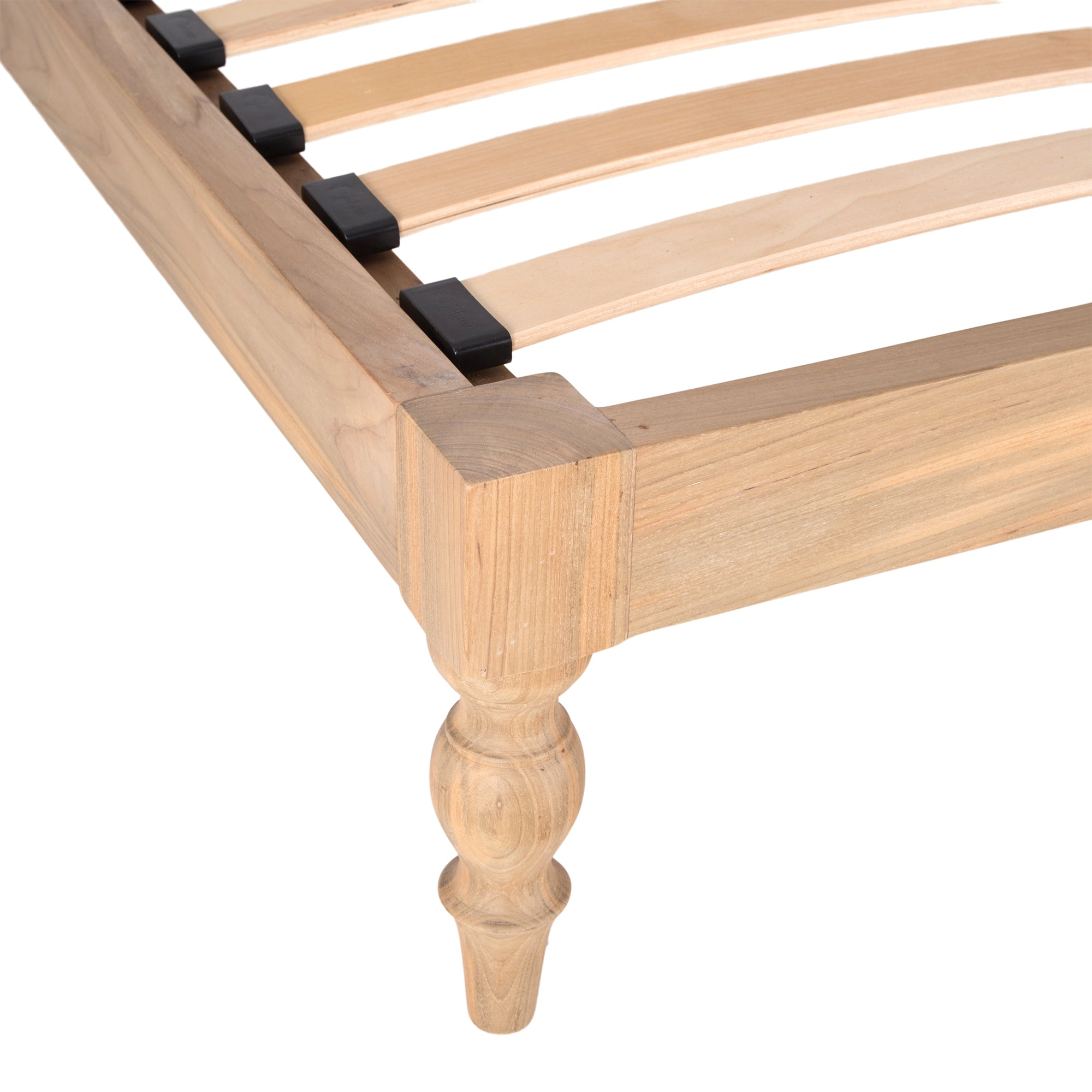 Natural wood platform bed with turned legs styled with white linen bedding and textured throw