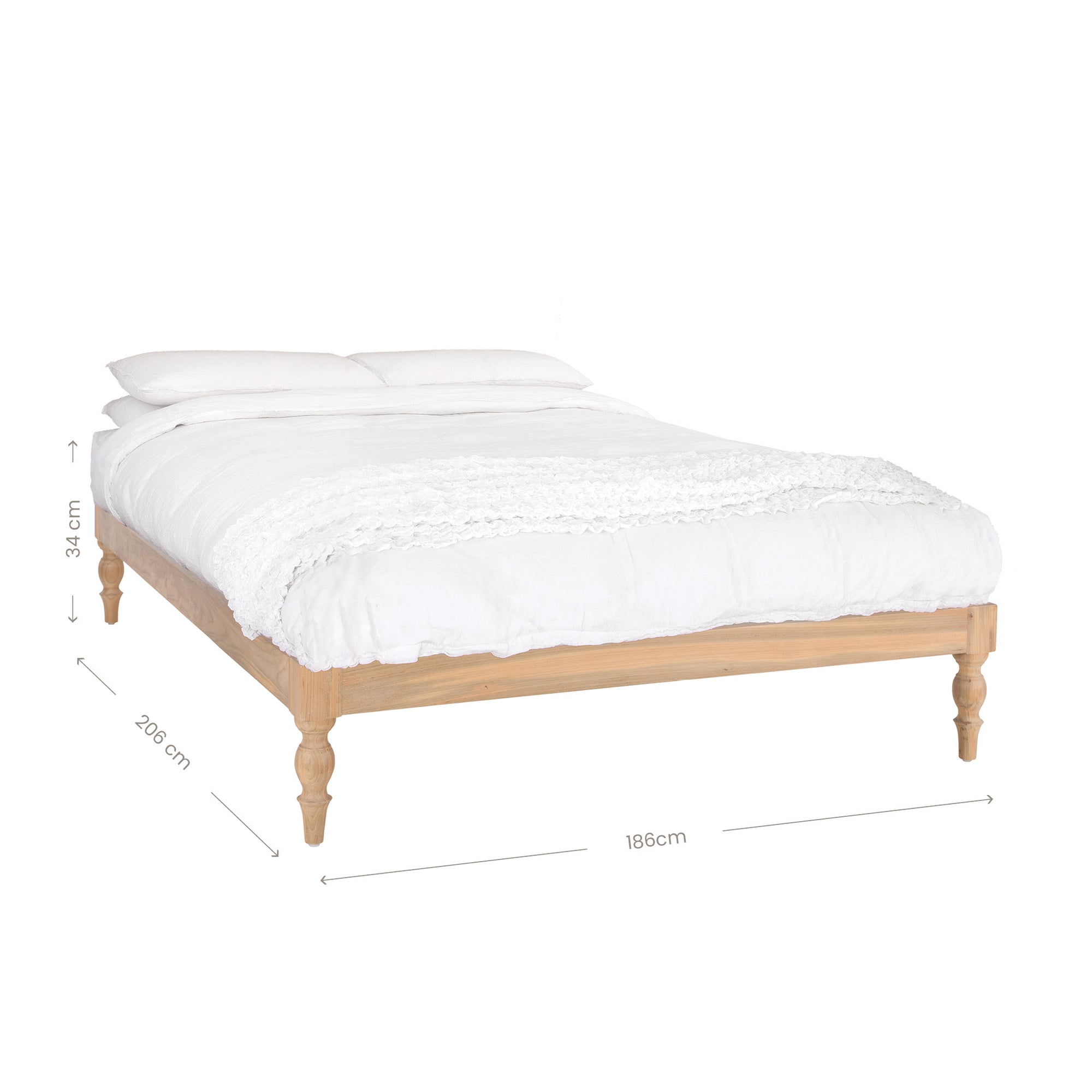Natural wood platform bed with turned legs styled with white linen bedding and textured throw