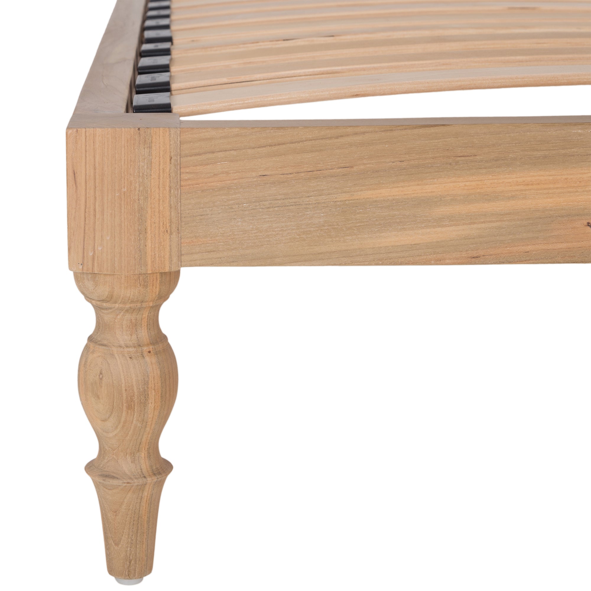 Natural wood platform bed with turned legs styled with white linen bedding and textured throw