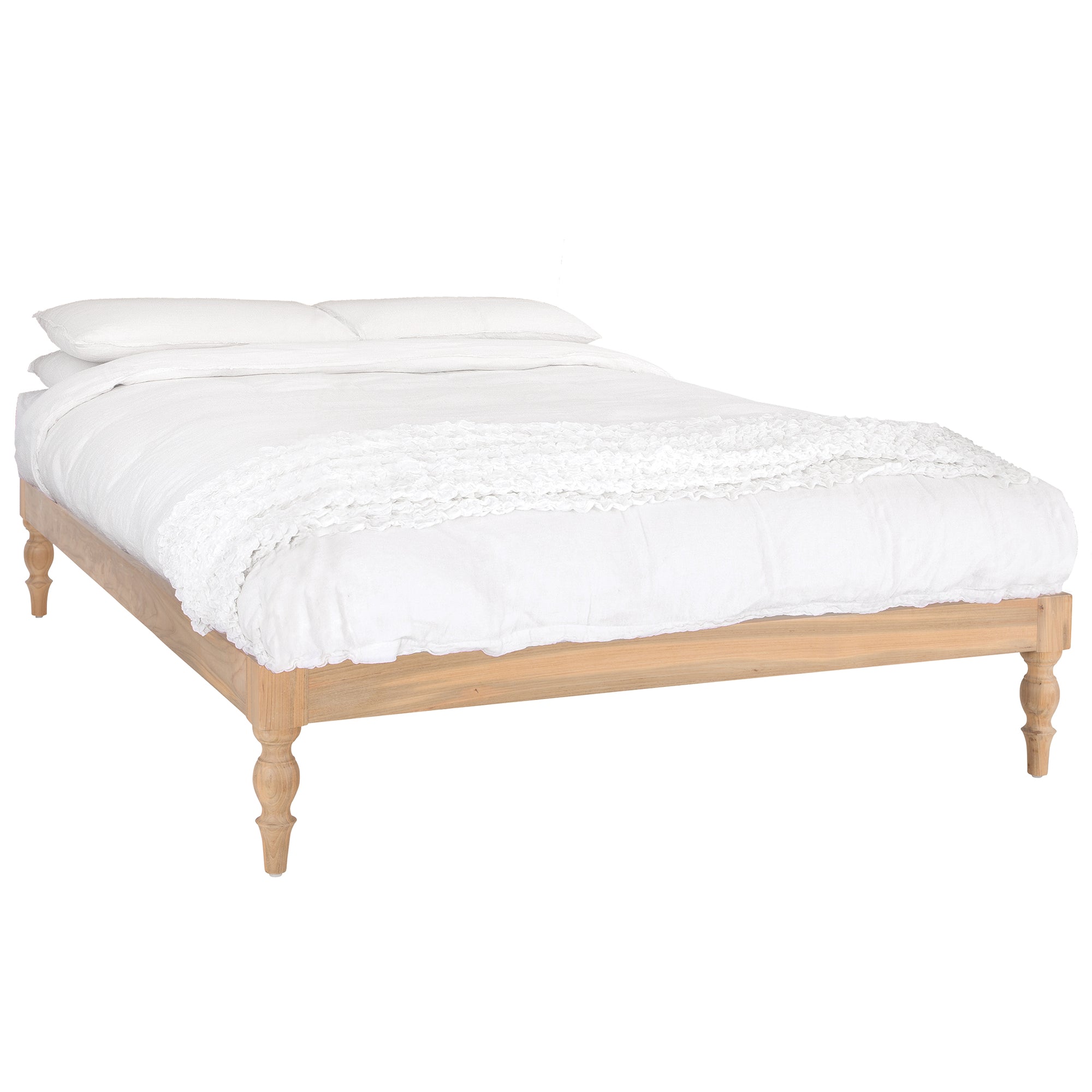 Natural wood platform bed with turned legs styled with white linen bedding and textured throw