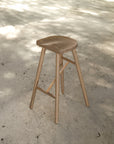 Natural wooden bar stool with sleek modern design and contoured seat, perfect for contemporary kitchen or bar settings