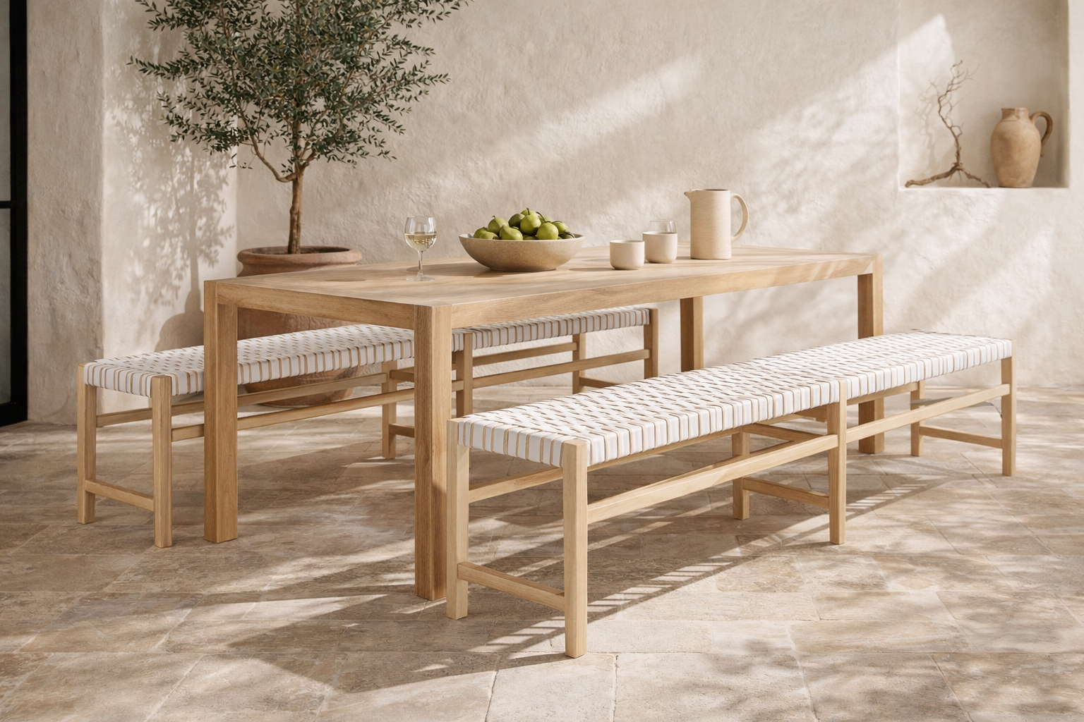 Nayasa bench in natural timber with white woven seat styled in a mediterranean dining space with stone floor and soft filtered light
