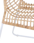 A handwoven rattan dining chair with a white metal frame, featuring an airy, open-weave design. The natural rattan seat and backrest bring an organic touch to contemporary and coastal interiors