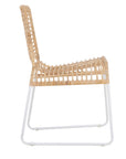 A handwoven rattan dining chair with a white metal frame, featuring an airy, open-weave design. The natural rattan seat and backrest bring an organic touch to contemporary and coastal interiors
