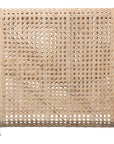 Modern coastal rattan lounge chair with curved silhouette and open weave pattern, featuring a natural finish and sleek white metal frame