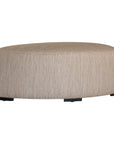 Curved upholstered ottoman with natural textured fabric and subtle black feet, ideal for contemporary living spaces