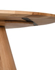A beautifully crafted round dining table made from solid oak, featuring a minimalist conical base for a timeless and contemporary design