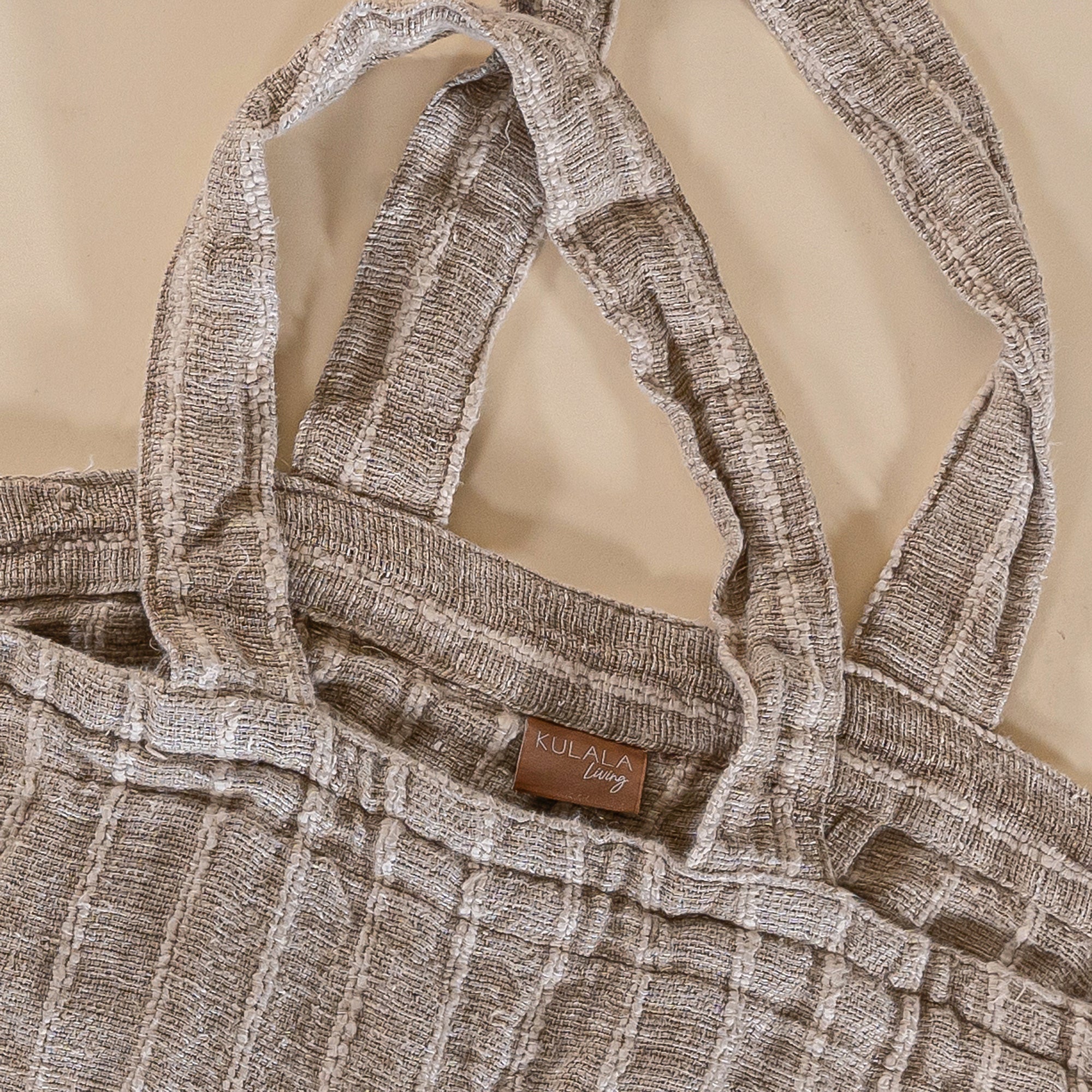 A generously sized striped linen market bag with a relaxed, slouchy design and exterior pocket. The neutral-toned fabric and soft texture create a timeless, effortless style