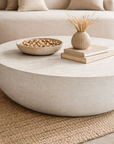 Tabati coffee table in eggshell hydro dipped finish with rounded low profile form styled in a soft neutral living room.