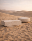Round Tabati coffee table and rectangular Nulusi coffee table in dune hydro dipped finish styled in a warm desert landscape.