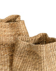 Talura basket in natural handwoven seagrass with organic rounded shape and softly structured open tops.