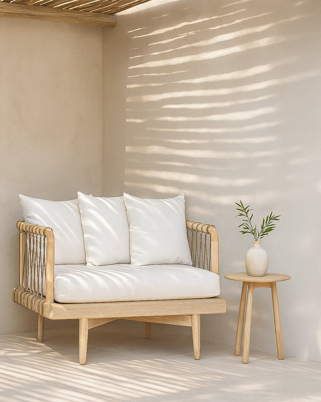 One Seater Tamala Sofa with teak frame and white cushions styled in a sunlit outdoor lounge with natural textures and a round side table