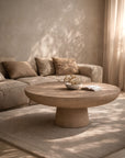 Tarran coffee table in nomad dune with rounded sculptural form styled in a warm sunlit living room with soft neutral furnishings.