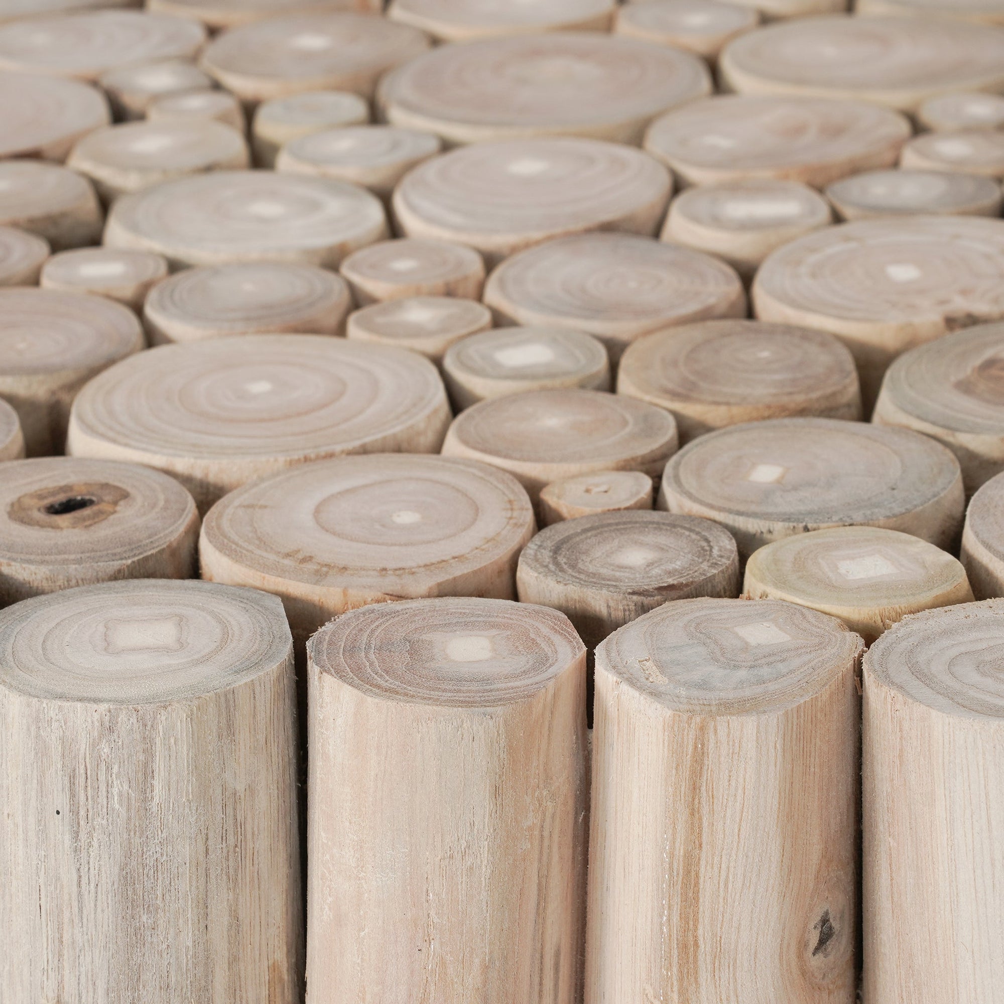 A round coffee table crafted from natural teak branches, arranged in a drum-style design. The organic texture and neutral tones make it a statement piece for coastal and contemporary interiors.