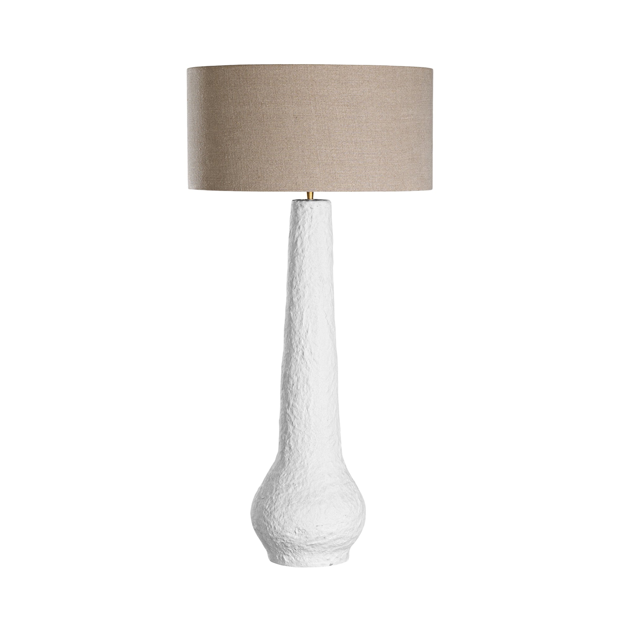 A textured paper mache white table lamp with elongated sculptural base and neutral linen shade, adding a refined and organic touch to any interior space