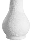 A textured paper mache white table lamp with elongated sculptural base and neutral linen shade, adding a refined and organic touch to any interior space