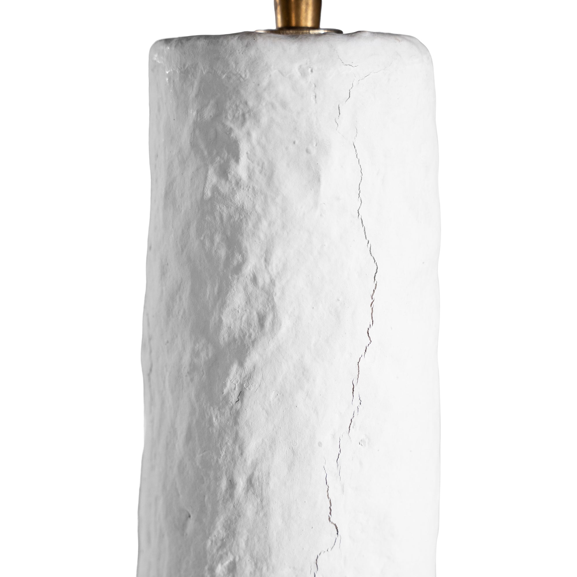A textured paper mache white table lamp with elongated sculptural base and neutral linen shade, adding a refined and organic touch to any interior space