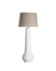 A textured paper mache white table lamp with elongated sculptural base and neutral linen shade, adding a refined and organic touch to any interior space