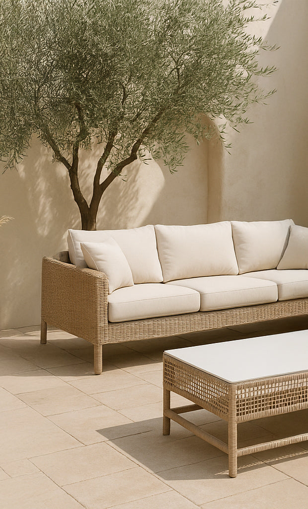 Tobago Coffee Table in a sun-drenched outdoor courtyard with neutral pavers, paired with a woven sofa and Mediterranean olive tree