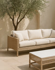 Tobago Coffee Table in a sun-drenched outdoor courtyard with neutral pavers, paired with a woven sofa and Mediterranean olive tree