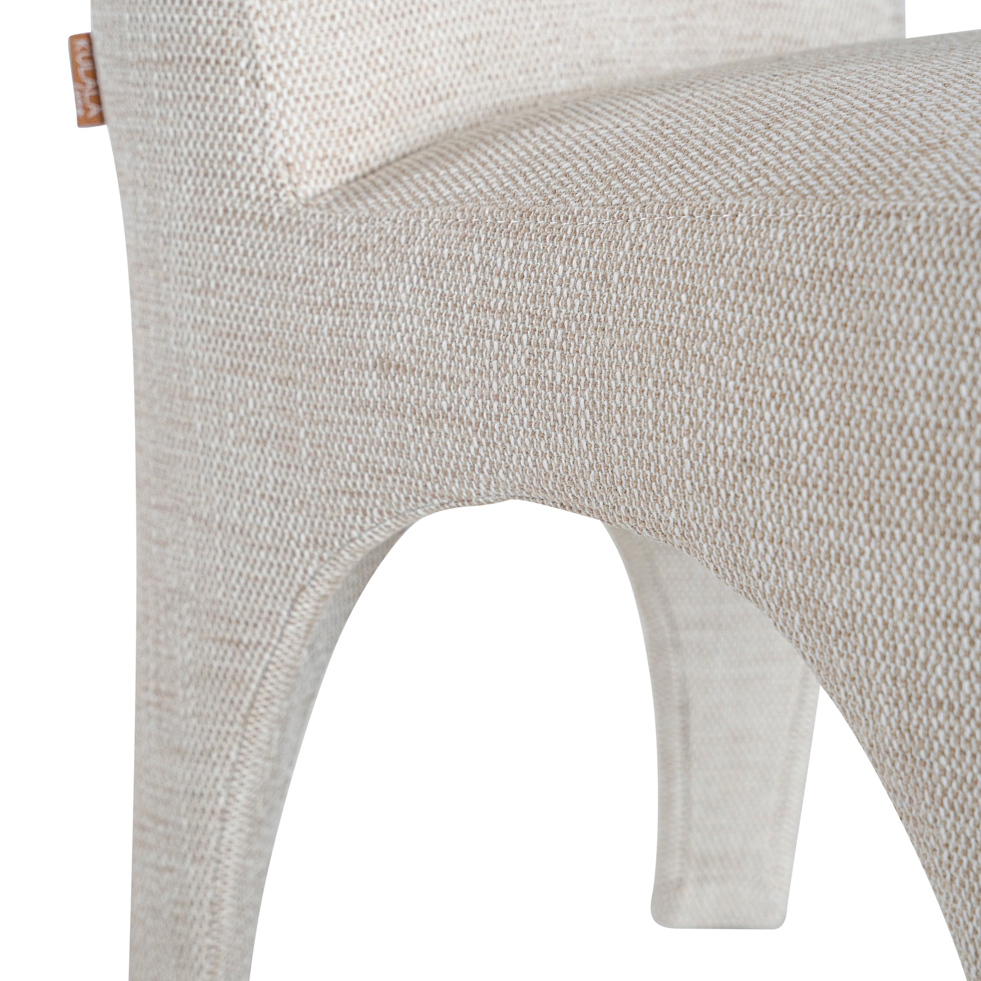 Contemporary arched dining chair upholstered in natural fabric, featuring sculptural curves and modern silhouette for refined dining spaces