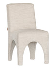 Contemporary arched dining chair upholstered in natural fabric, featuring sculptural curves and modern silhouette for refined dining spaces