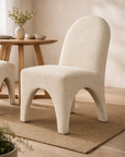 Cream tucan dining chairs paired with a timber table in a light filled modern organic australian dining room