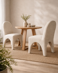 Cream tucan dining chairs paired with a timber table in a light filled modern organic australian dining room