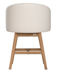 A modern upholstered dining chair featuring a curved backrest and soft white fabric, supported by sturdy oak timber legs with a natural finish