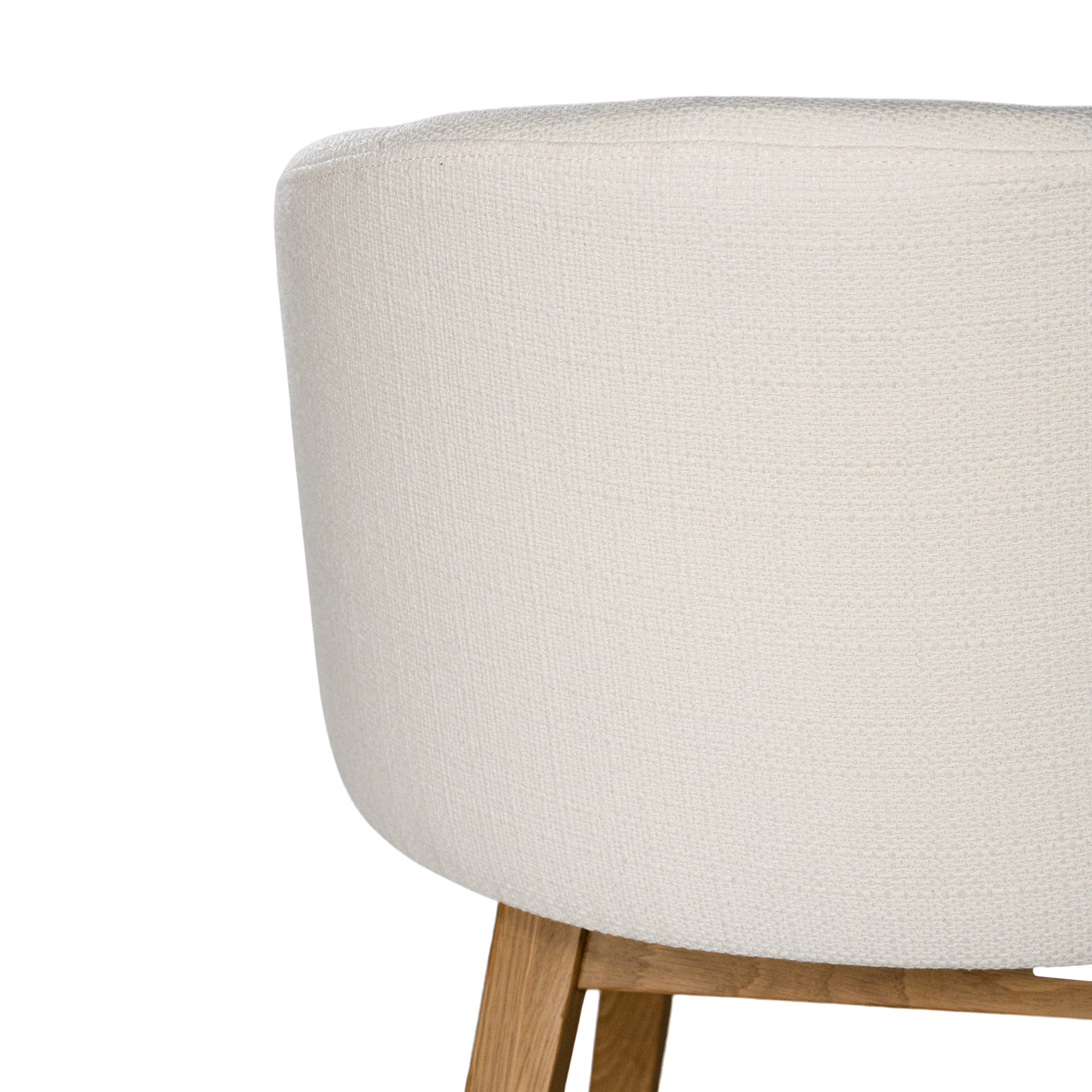 A modern upholstered dining chair featuring a curved backrest and soft white fabric, supported by sturdy oak timber legs with a natural finish
