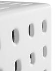 A modern white concrete side table with perforated details, blending sculptural design with functional seating for indoor and outdoor spaces