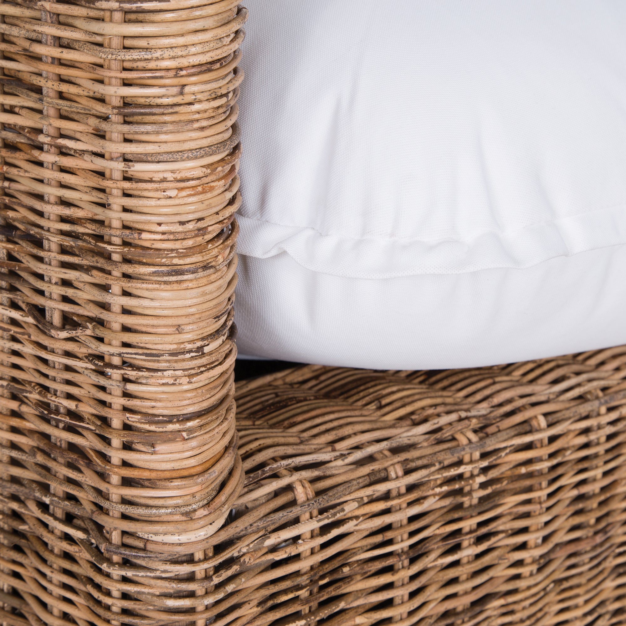 A contemporary white natural woven sofa with plush, generously filled cushions, offering both comfort and style for a refined coastal or modern living space.