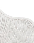 White rattan dining chair with curved back and slim metal legs, perfect for modern and stylish dining settings