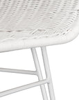 White rattan dining chair with curved back and slim metal legs, perfect for modern and stylish dining settings