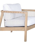 Wooden accent chair with white cushions and sleek spindle detailing, perfect for modern coastal and relaxed living spaces