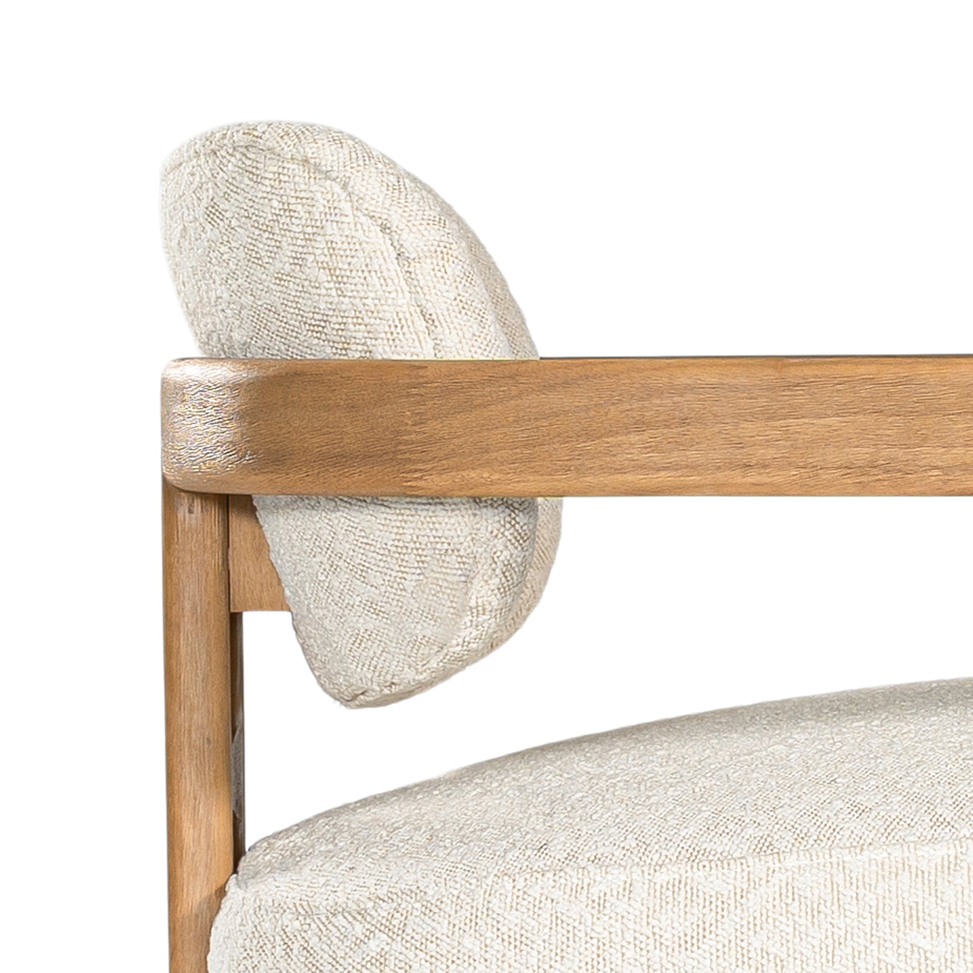 Stylish wooden occasional chair with boucle upholstery, set in a minimalist dining space with a sculptural stone table and an olive tree in a textured planter