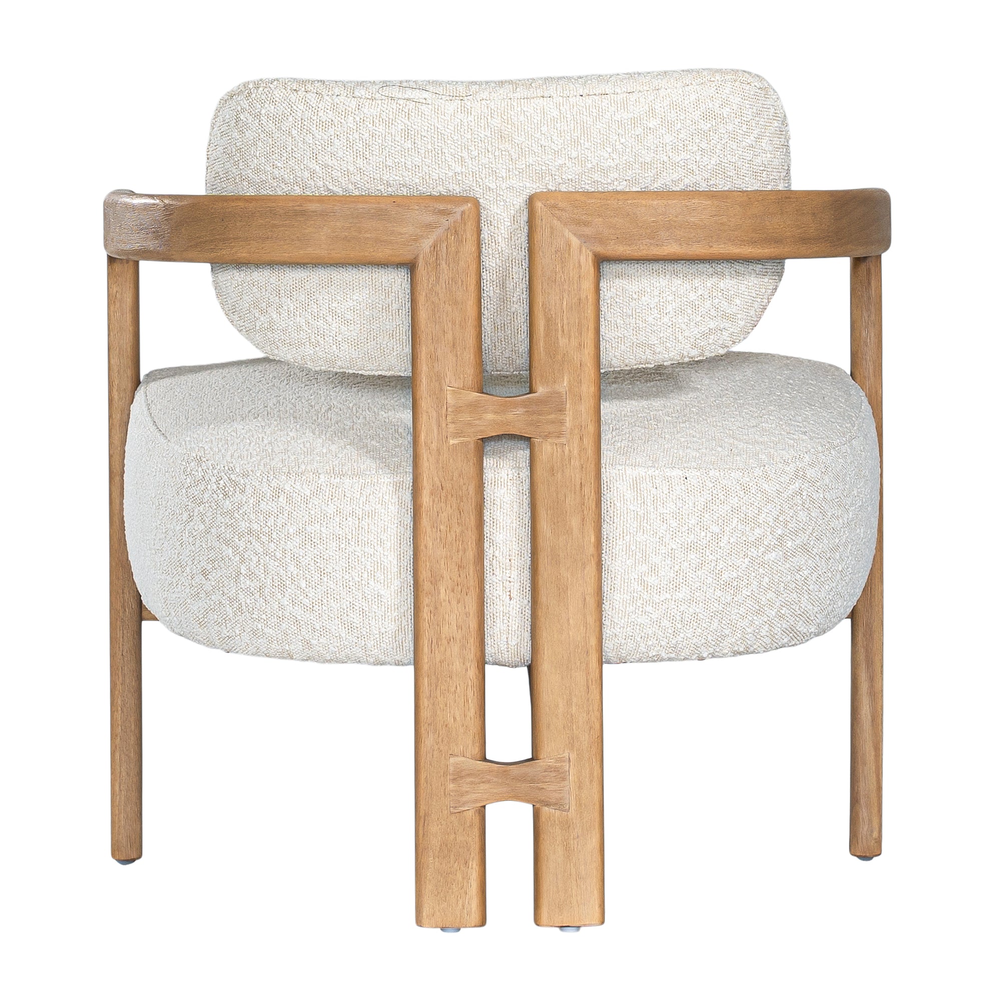 Stylish wooden occasional chair with boucle upholstery, set in a minimalist dining space with a sculptural stone table and an olive tree in a textured planter