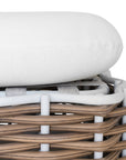 Stylish outdoor rattan ottoman with white cushions, perfect for creating a comfortable and modern alfresco space